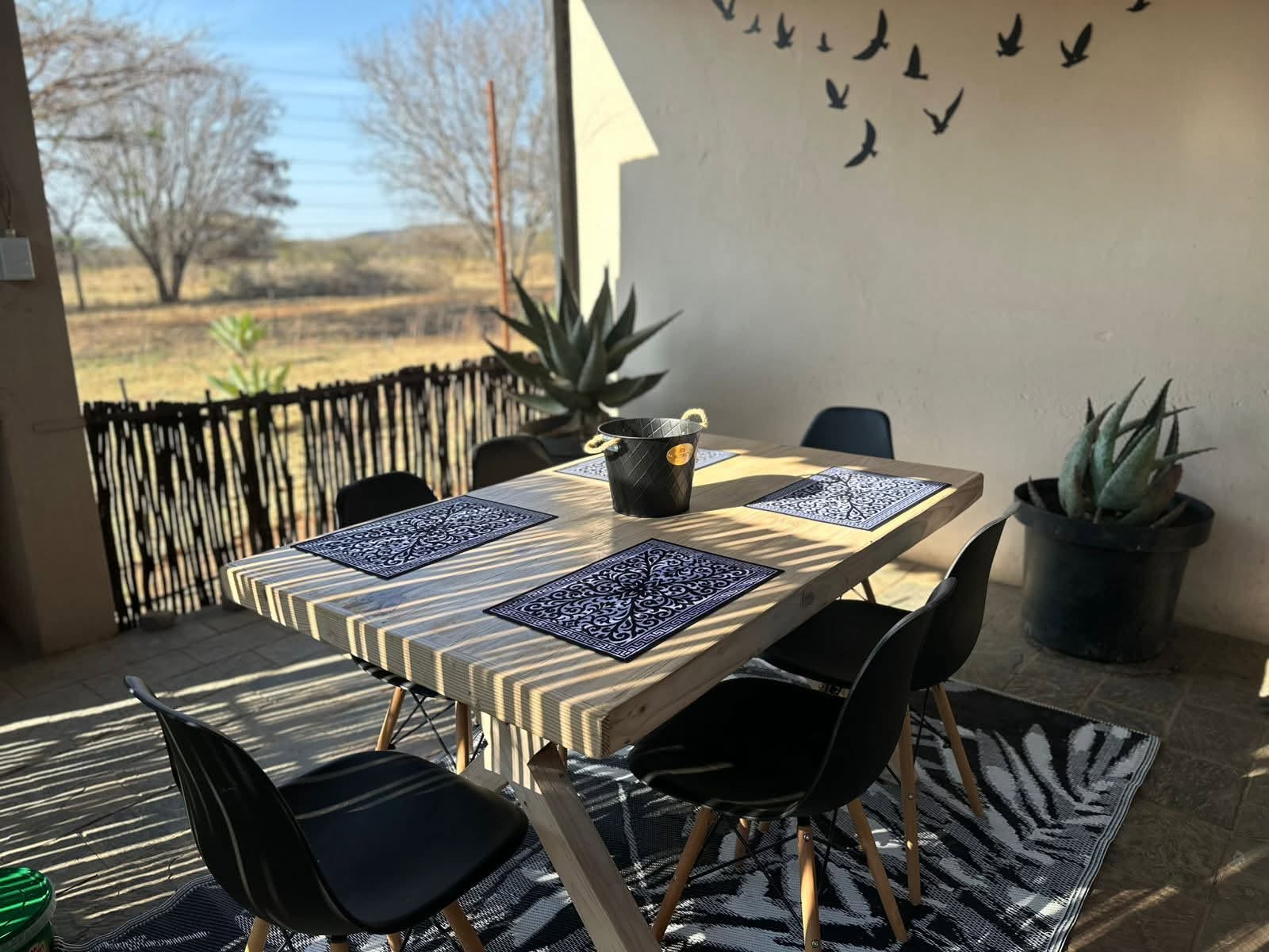 Private stoep dining table with aloe plants and countryside views at the Aloe Suite